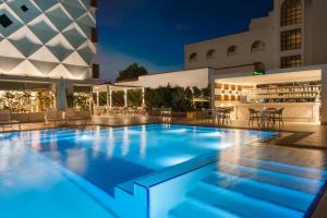 a pool at night with tables and chairs at Elite World Marmaris - Adult Only in Marmaris