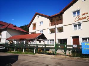 a large white building with a fence in front of it at Casa Liana in Buşteni