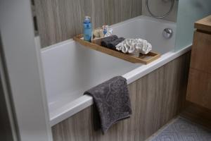 a bathroom with a bath tub with a towel at Napfény Resort Apartman in Balatonlelle