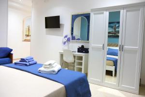 1 dormitorio con cama y escritorio con espejo en CARPE DIEM B&B en Castellabate