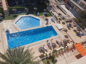 an overhead view of a large swimming pool with chairs andarios at Nogalera Sea&Sun Apartment in Torremolinos