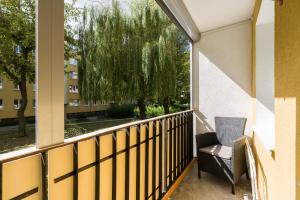 Un balcón con una silla y un árbol en Family Apartment Poznań Rataje by Renters en Poznan