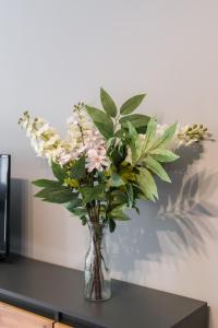 a vase filled with flowers on a table at Family Apartment Poznań Rataje by Renters in Poznań