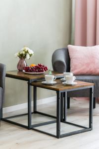 a coffee table with two cups and a bowl of fruit at Family Apartment Poznań Rataje by Renters in Poznań