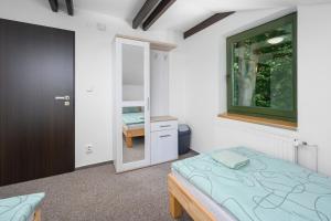 Pokoje Wimbledon في ليبيريتس: غرفة نوم بسرير ومرآة