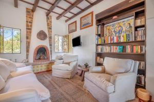 a living room with white chairs and a fireplace at Villa Claramunda in Cala D'or