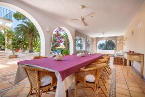 a dining room with a purple table and chairs at Villa Claramunda in Cala D'or