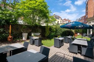 a patio with tables and chairs and an umbrella at Martin's Brussels EU in Brussels