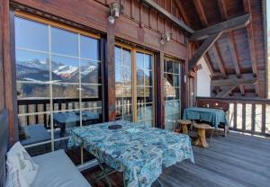 a table on a porch with a view of the mountains at Appartement La Gentiane 63 in Chateau-d'Oex