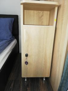 une armoire en bois à côté d'un lit dans une chambre dans l'établissement Imádó Vendégház, à Cernatu de Sus