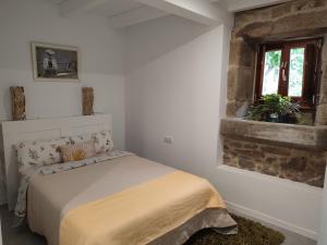 Amés的住宿－A Casa Do Boi，一间卧室设有一张床和一个窗口