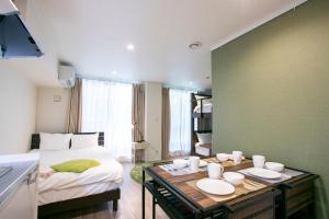 Un dormitorio con una cama y una mesa con platos. en Minn Kamata, en Tokio