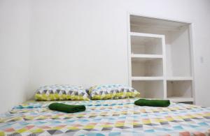 um quarto com uma cama com almofadas em Pousada da Sú em Bertioga