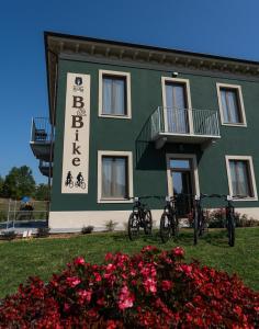 zielony budynek z rowerami zaparkowanymi przed nim w obiekcie B & Bike di Ristorante Italia w mieście Mombello Monferrato