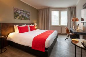 a hotel room with a large bed with red pillows at Martin's Brussels EU in Brussels