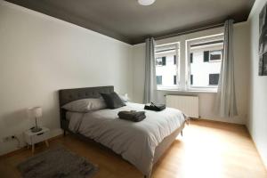 a bedroom with a bed and a large window at [Königstraße]- Helle Wohnung im Herzen Stuttgarts in Stuttgart