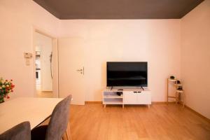 sala de estar con TV de pantalla plana en la pared en [Königstraße]- Helle Wohnung im Herzen Stuttgarts en Stuttgart