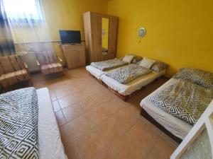 a bedroom with two beds and a tv in it at Apartmány Viola in Štúrovo