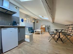 uma cozinha e sala de estar com mesa e cadeiras em Aurore Appartements Carcassonne em Carcassonne