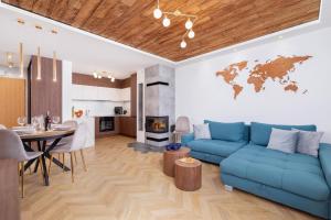 a living room with a blue couch and a table at Premium Apartments Salwatoriańska Mountain View Zakopane by Renters Prestige in Zakopane