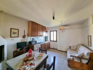 a living room with a table and a kitchen at Appartamenti Tortorella in Pelago