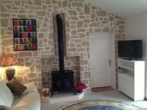 sala de estar con pared de piedra y chimenea en Stunning Cottage with Pool in Provence France, en Lorgues