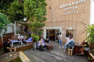 a group of people sitting on a deck in front of a building at Abraham Tel Aviv in Tel Aviv