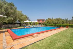 einen Pool im Garten mit Stühlen und Sonnenschirmen in der Unterkunft Finca Margarita by Mallorca House Rent in Felanitx