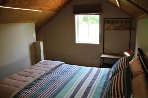 a bedroom with a bed and a window at The Red Barn - Lake Okareka Holiday Home in Rotokawa