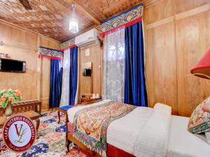 a bedroom with two beds and a tv in it at Lake Victoria Houseboats in Srinagar