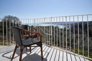 a chair sitting on a deck with a view of the ocean at Villa Caravaggio Comfort e Relax in Rocca San Giovanni