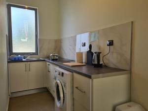 a kitchen with a sink and a washing machine at Vila Tatjana in Vuno