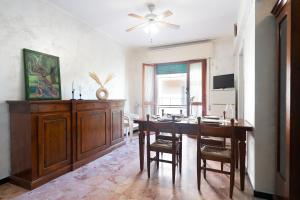 uma sala de jantar com uma mesa e uma ventoinha de tecto em [VIA CRISPI] Grande e comodo in zona tranquilla. em Pietra Ligure