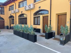 uma fila de vasos de plantas em frente a um edifício em Residenze Niguarda em Milão