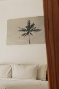 a picture of a palm tree above a bed at Sikara Lombok Hotel in Kuta Lombok
