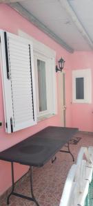 - une table de ping-pong dans une pièce dotée d'un mur rose dans l'établissement BeachFront House - Sant'Angelo Ischia, à Ischia