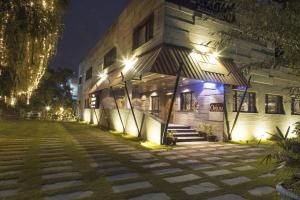 a building with lights on the side of it at night at Royaute Luxury Suites and Hotel Gulberg Lahore in Lahore