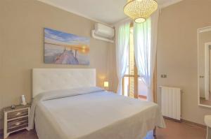 ein Schlafzimmer mit einem weißen Bett und einem Fenster in der Unterkunft Villetta Bosco in Corsanico-Bargecchia