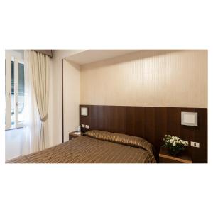 a bedroom with a bed with a wooden headboard at Hotel Margherita in Monterosso al Mare