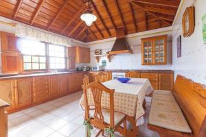 a kitchen with a table and chairs and a kitchen with wooden cabinets at Balcón Atlántico in Fuencaliente de la Palma