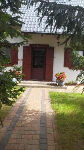 una casa con un camino de ladrillo delante de ella en 4 Pory Kaszub - Domek z banią i sauną, en Skoszewo