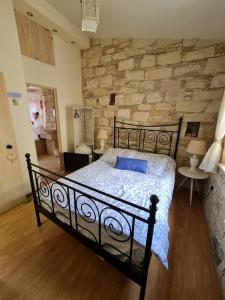 a bedroom with a black bed and a stone wall at Haven in Limassol