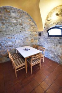 una mesa y sillas en una habitación con una pared de piedra en Roman Tower, en Cipressa