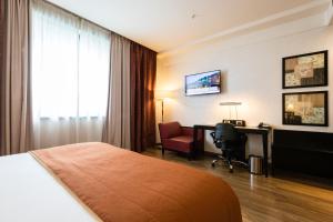 um quarto de hotel com uma cama, uma secretária e um computador em Crowne Plaza Milan Malpensa Airport, an IHG Hotel em Case Nuove