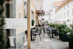 a street with tables and chairs outside a restaurant at Hotel Mariahilf in Graz