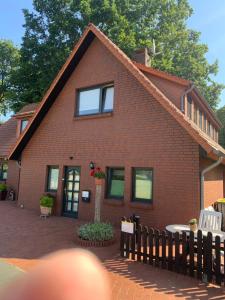 a red brick house with a fence in front of it at Ferienwohnung Kramer in Colnrade