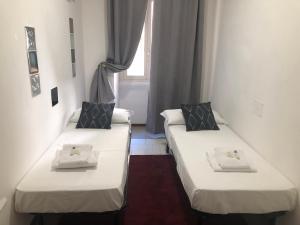 2 łóżka w małym pokoju z oknem w obiekcie ROMAN APARTMENT in TRASTEVERE w Rzymie