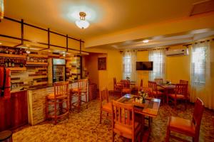 restauracja ze stołami i krzesłami oraz bar w obiekcie Crest Safari Lodge w mieście Arusza