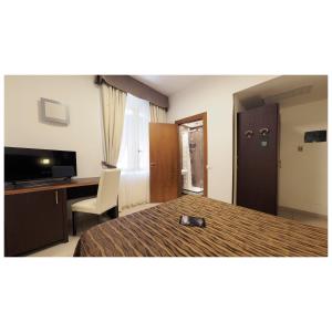 a hotel room with a bed and a desk and a television at Hotel Margherita in Monterosso al Mare