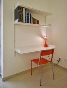 uma cadeira e uma secretária com livros na parede em Casa Argento em Sciacca